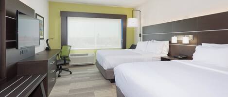 A hotel room with two beds, a desk, a chair, a television, and a window.