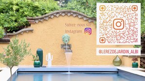 A pool with a decorative wall, a cactus, and a fountain. - Le Rez de Jardin Albi (Albi)