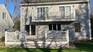 A two-story house with a front porch, a balcony on the second floor, and a well-maintained lawn. - Lakefront Home for Rent (Moultonborough)