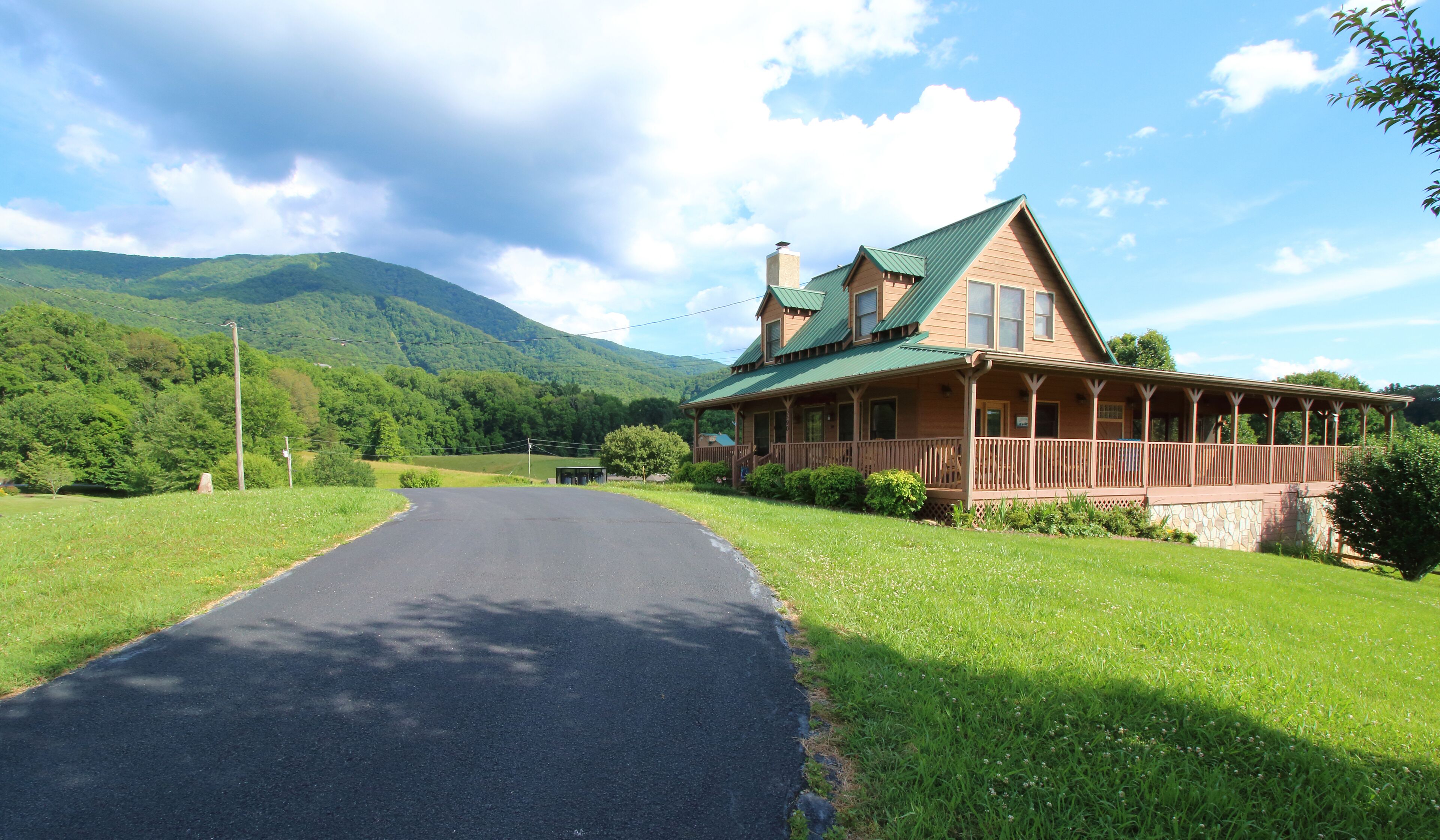 Un chalet doté d’une véranda et surplombant une chaîne de montagnes.