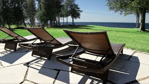Des fauteuils de jardin confortables sur une terrasse offrant une vue sur la mer.