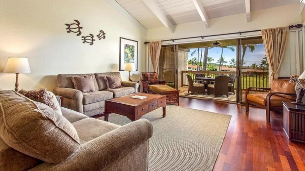 A spacious living room with a sofa set, a coffee table, and a dining area with a table and chairs. - Spacious Executive Retreat in Paradise + 3 mins from Turtle Beach! (Kailua-Kona)