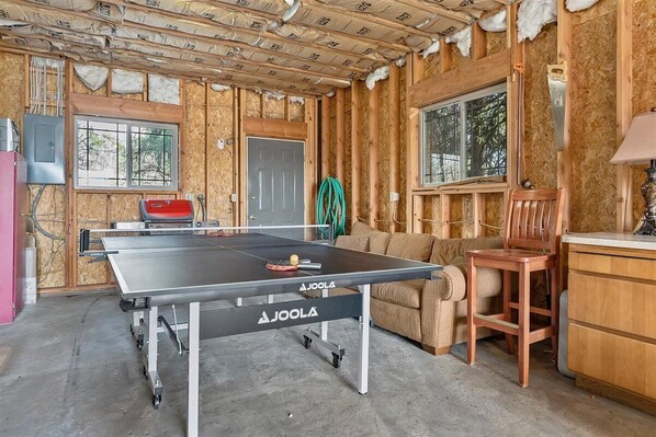 A room with a ping pong table, a couch, a chair, and a door. - **CJ's Lakeview Cabin HotTub Spotless! GameRoom Parking Stocked Kitchen** (McCall)