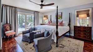 A bedroom with a large bed, a ceiling fan, a dresser, and a chair. - Charming Cashiers Cottage with View of Chimney Rock Adjoining High Hampton (Cashiers)