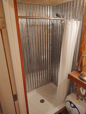 Een douche, handdoeken, zeep, shampoo