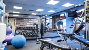 A gym with exercise equipment, dumbbells, and exercise balls. - Lux Blackstone Mountain Suite with Amazing Views (Canmore)
