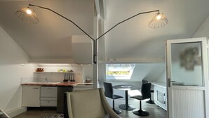 Um loft moderno com cozinha, área de jantar e um espaço de estar aconchegante.