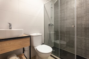 A modern bathroom with a white sink, toilet, and glass-enclosed shower. - Zarco B&B - Bed and Breakfast (Funchal)