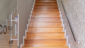 A wooden staircase with a handrail, leading upwards. - Zarco B&B - Bed and Breakfast (Funchal)