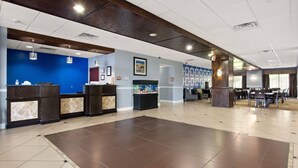 A spacious lobby with a reception desk, a large aquarium, and a seating area with tables and chairs. - Portland Inn & Suites (Portland)