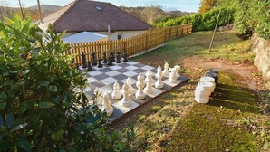 A chessboard set up outdoors with a house in the background.