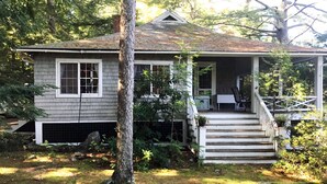 A two-story house with a front porch, a small staircase, and a covered porch area.