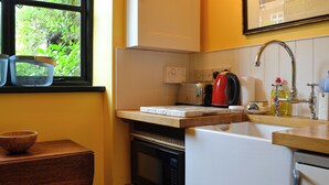 Cocina compacta con microondas, tostadora y lavabo.