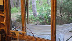 A wooden interior with a sign reading 'The South Enders Rock on Beaver Island U.S.A.' and a view of a forested area through large windows.