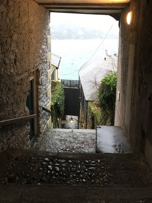 Un estrecho sendero de piedra que lleva a un edificio con vista a una masa de agua.