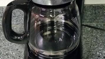 A BLACK+DECKER coffee maker with a digital display on a granite countertop.