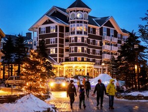A multi-story hotel with a central tower, balconies, and a snow-covered driveway. - 1BR Allegheny Springs | No Resort Fee | Ski-In/Out | Sleeps 4 (Snowshoe)