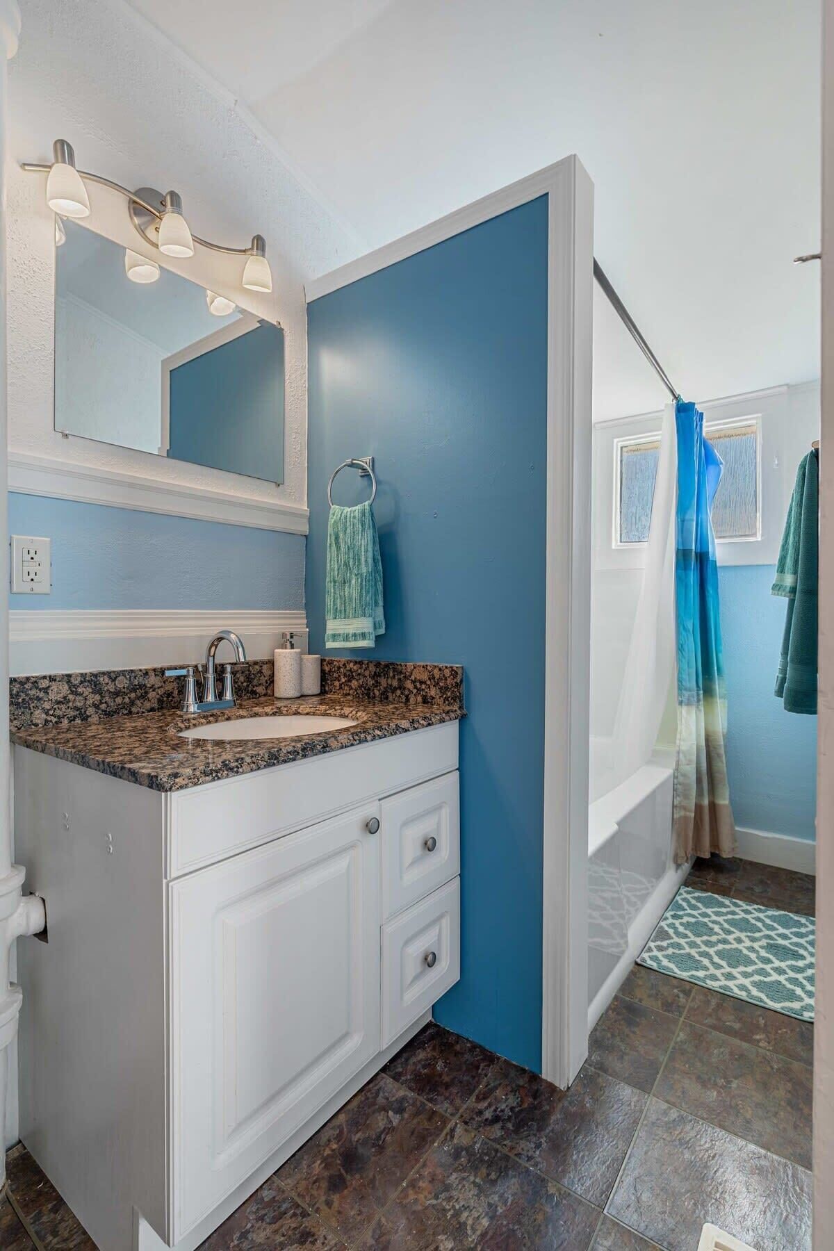 Bathtub, hair dryer, towels, shampoo