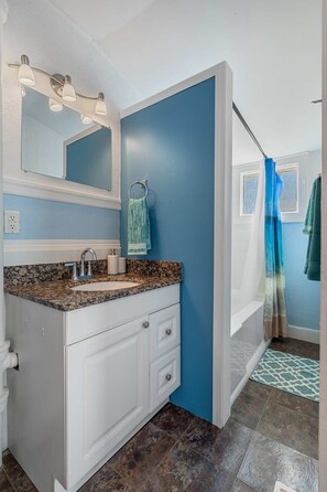 Bathtub, hair dryer, towels, shampoo