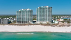 Two high-rise hotels with a beach and ocean in the foreground.