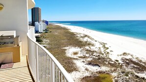 A balcony with a view of a beach and ocean.