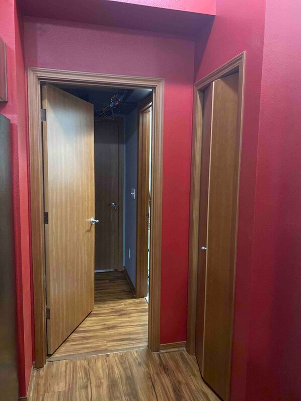 A narrow hallway with wooden doors and a wooden floor. - Lake Kathleen Duplex (Renton)