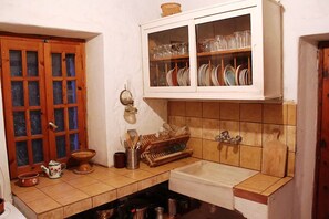 Une cuisine avec des meubles en bois, un évier et un pare-feu en carrelage.