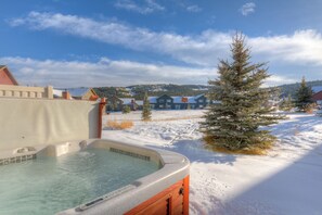 Ein Whirlpool in verschneiter Winterlandschaft unter klarem Himmel.