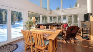 A spacious living area with a wooden dining table, leather sofa, and a mounted animal head. - Ski in/out home w/private hot tub, sauna, fireplace & great views - Low Dog Mountain Chalet (Big Sky)