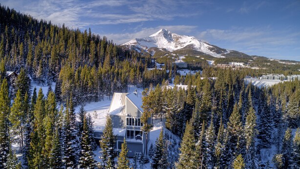 A mountain lodge surrounded by snow-covered trees, with a view of a snow-capped mountain in the background. - Ski in/out home w/private hot tub, sauna, fireplace & great views - Low Dog Mountain Chalet (Big Sky)