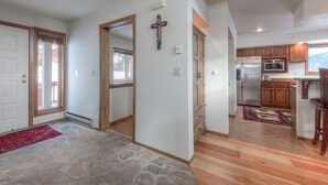 A spacious kitchen with wooden cabinets, a stainless steel refrigerator, and a microwave. - Private Hot Tub | Golf Course | Nordic Skiing | Big Sky Awaits (Big Sky)