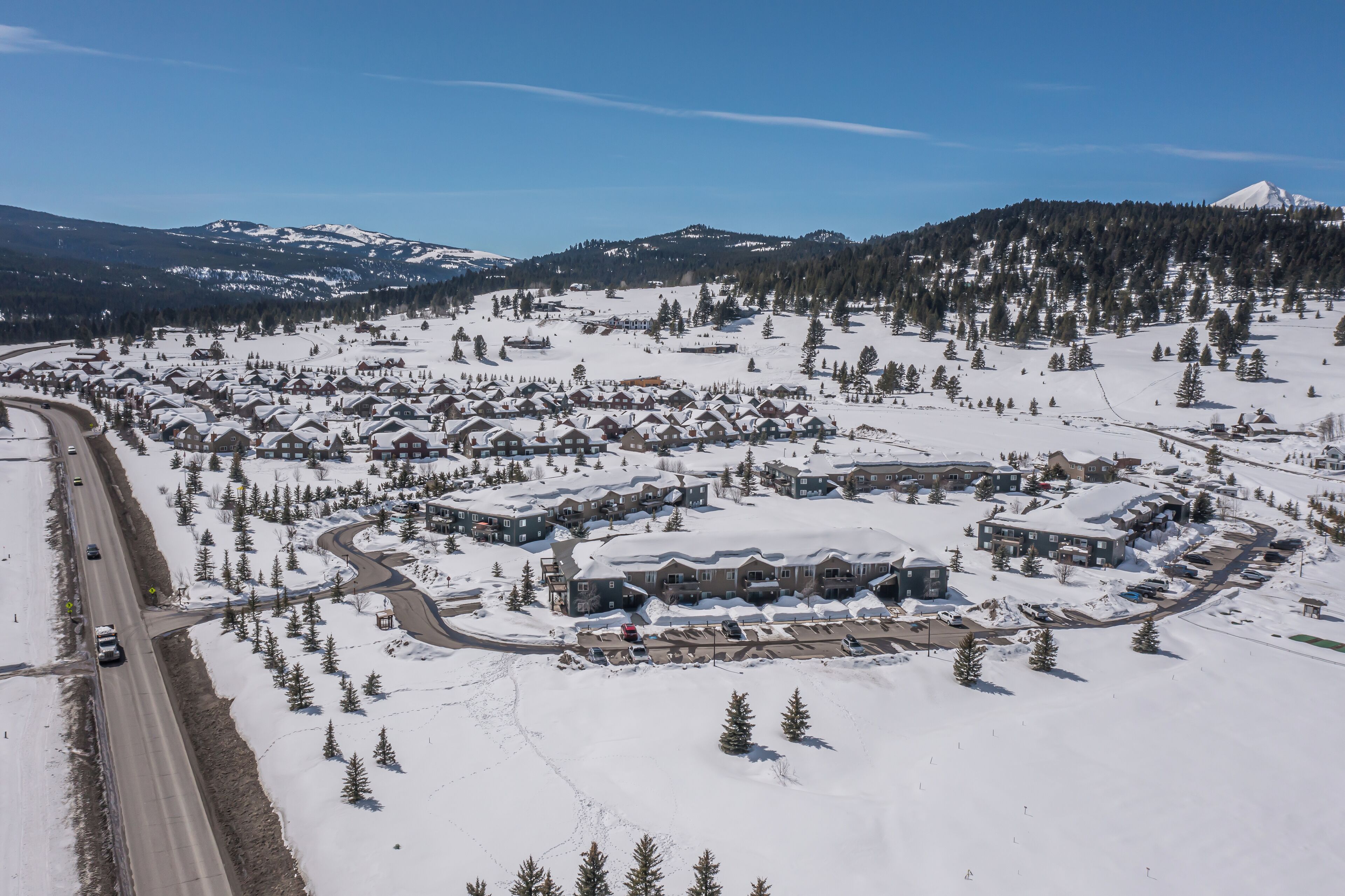 A snow-covered residential area with houses and a road.