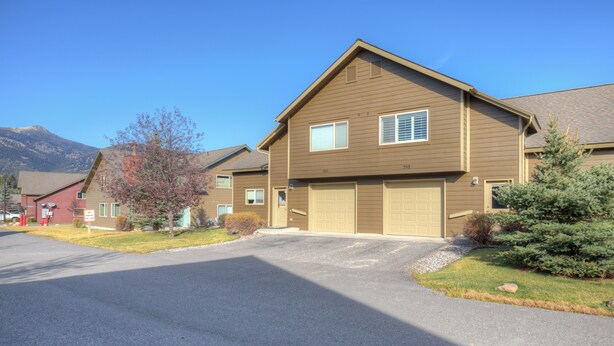 A two-story residential building with a garage, a driveway, and a well-maintained lawn. - Beautiful home w/gorgeous views & fireplace, close to Big Sky Town Center - Firelight Cottage (Big Sky)
