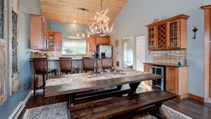 A spacious kitchen with a large wooden table, wooden cabinets, and a chandelier. - Beautiful home w/gorgeous views & fireplace, close to Big Sky Town Center - Firelight Cottage (Big Sky)