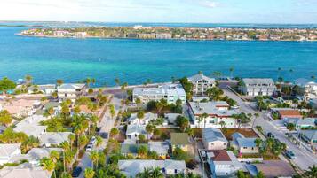 Uma área residencial costeira com casas, uma ponte e vista para o oceano.