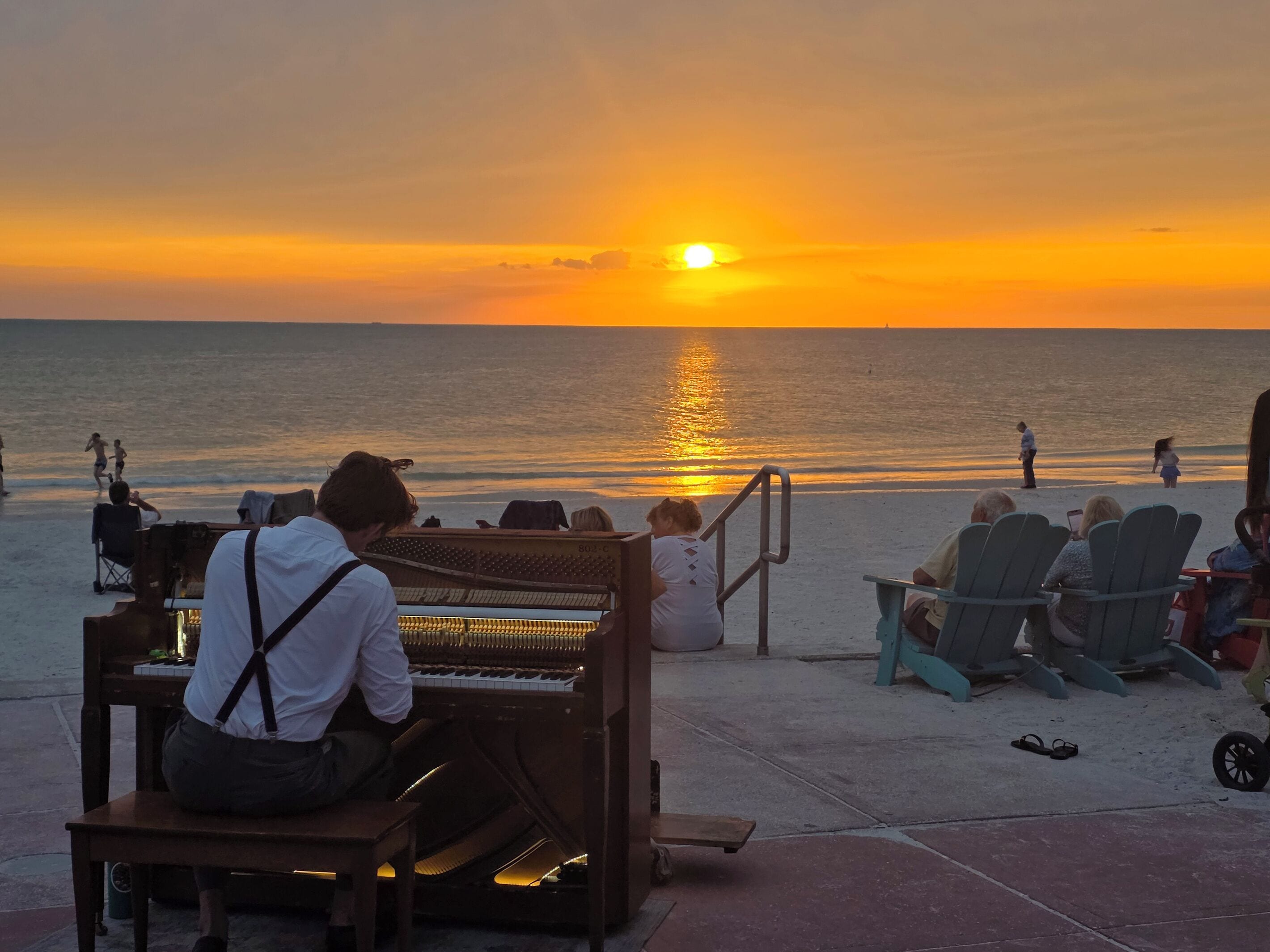 Ein Klavier auf einer Bühne mit Blick auf einen Sonnenuntergang.