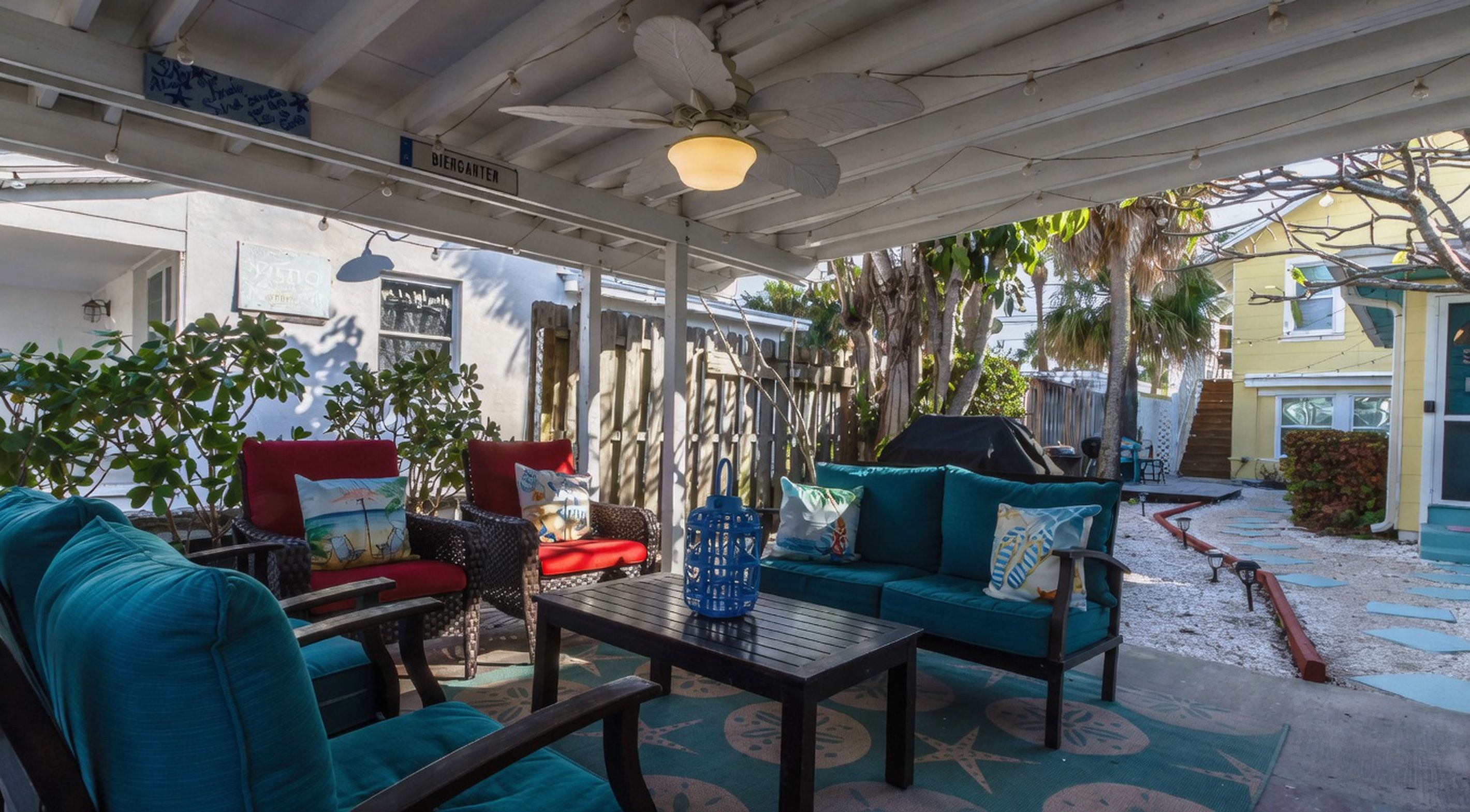 An outdoor patio with a covered seating area, a ceiling fan, and a sign labeled 'BIERANTER'.