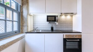 Una cocina compacta con microondas, horno y lavabo integrados.