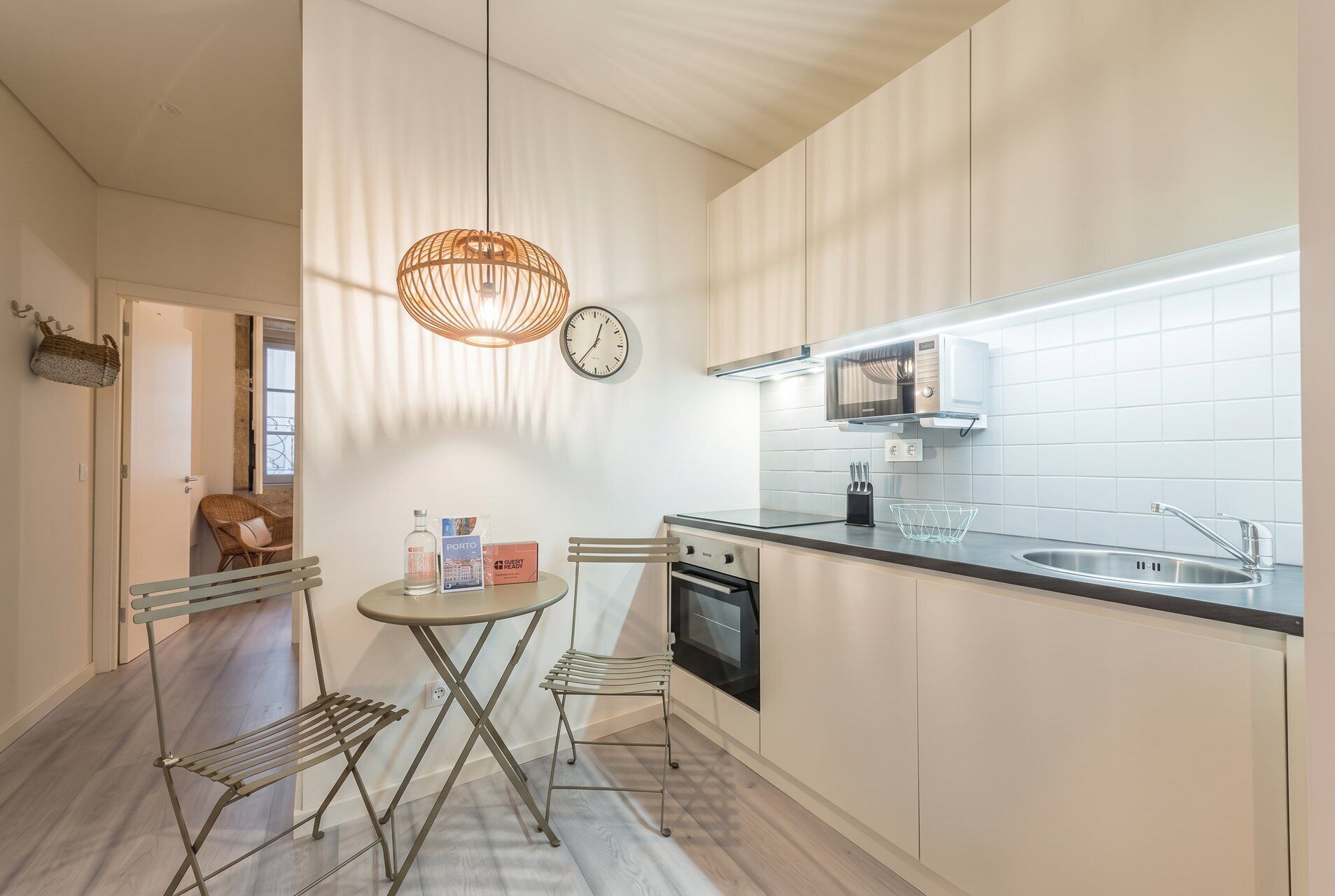 A modern kitchen with a central island, stainless steel appliances, and a hanging light fixture.