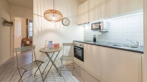 Een moderne keuken met een centraal eiland, roestvrijstalen apparatuur en een hangende lamp.