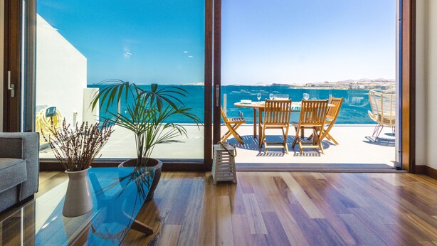 A modern room with a large sliding glass door leading to a balcony with a view of the sea. - Taliarte Lighthouse Top Views Marea (Taliarte)