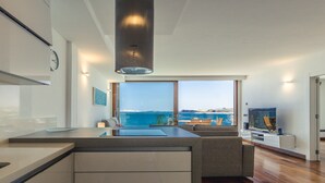 A modern kitchen with a view of the sea, a dining area with a view, and a living room with a television. - Taliarte Lighthouse Top Views Marea (Taliarte)