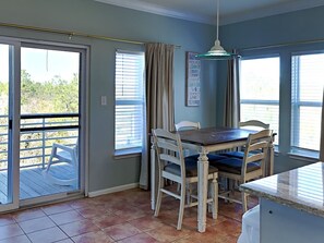 A dining area with a table and chairs, a ceiling light, and a view through the glass door. - Lakefront Condo, Close to Beach with Resort Amenities (Orange Beach)