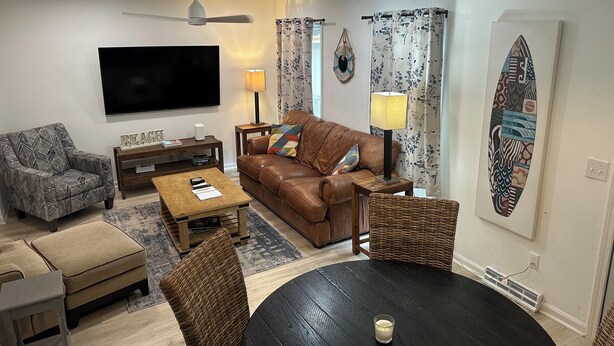 Ein Wohnzimmer mit Fernseher, Sofa, Couchtisch und Sesseln.