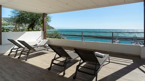 Un balcon avec deux fauteuils et une vue sur la mer.