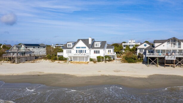 Beachfront houses with balconies, a sandy beach, and ocean waves. - Stay @ Ocean Spray at the Blue Horizon (Sullivan's Island)