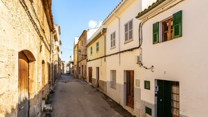 Una stretta via fiancheggiata da edifici con architettura tradizionale, caratterizzata da porte e finestre ben visibili.