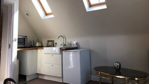 A compact kitchen with a sink, a small refrigerator, and a window. - Beautiful Apartment in Rostrevor Northern Ireland (Rostrevor)