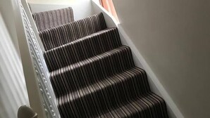 A staircase with striped carpet and white balusters. - Beautiful Apartment in Rostrevor Northern Ireland (Rostrevor)