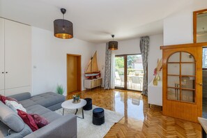 Un salon moderne avec un canapé gris, une petite table ronde et un meuble en bois.